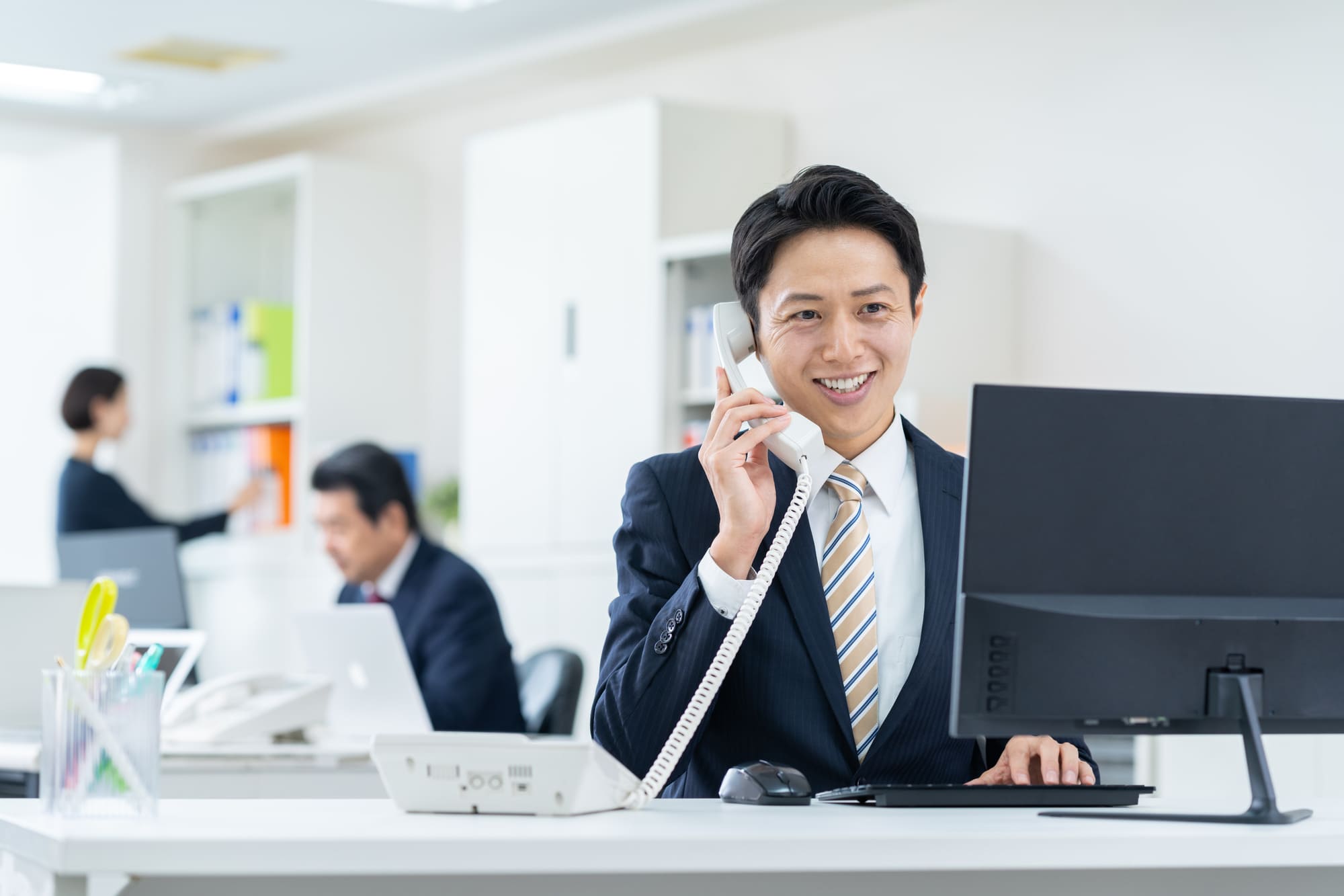 電話対応をしているスーツ男性